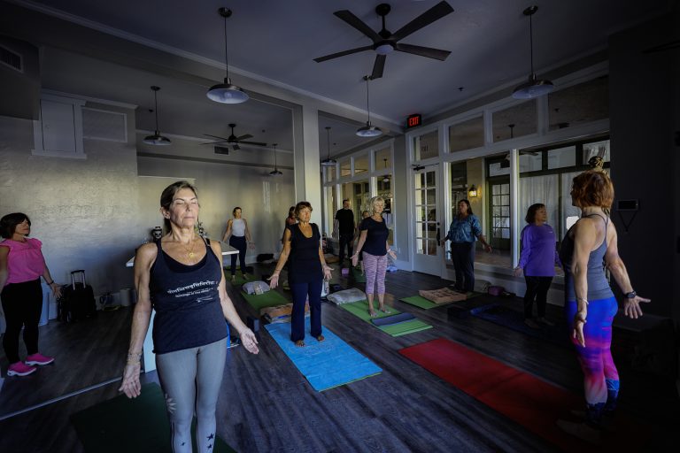 a group of people standing on mats in a room
