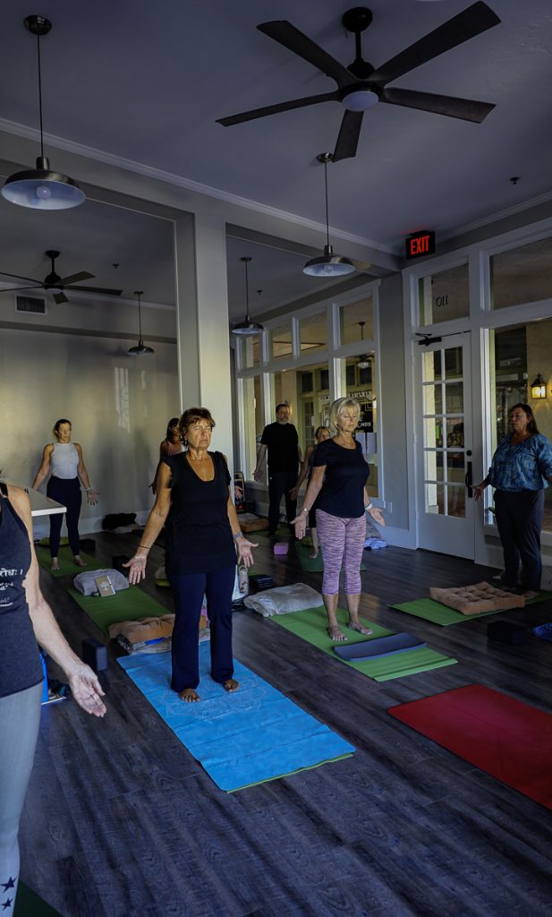 a group of people standing on mats in a room