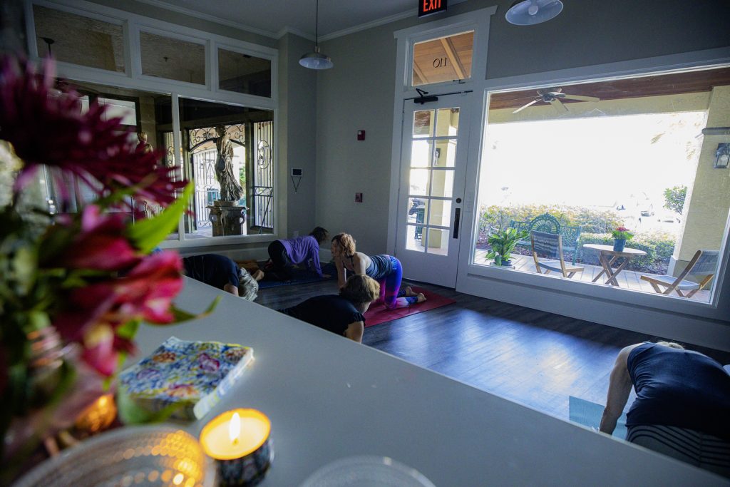 a group of people doing yoga in a room
