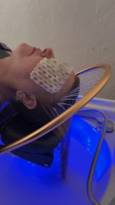 Close-up of guest using hydrotherapy basin with glowing LED light therapy in Treasure Coast